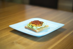 Die Patties auf Toast, Salat und mit Tomatensauce anrichten (vh)