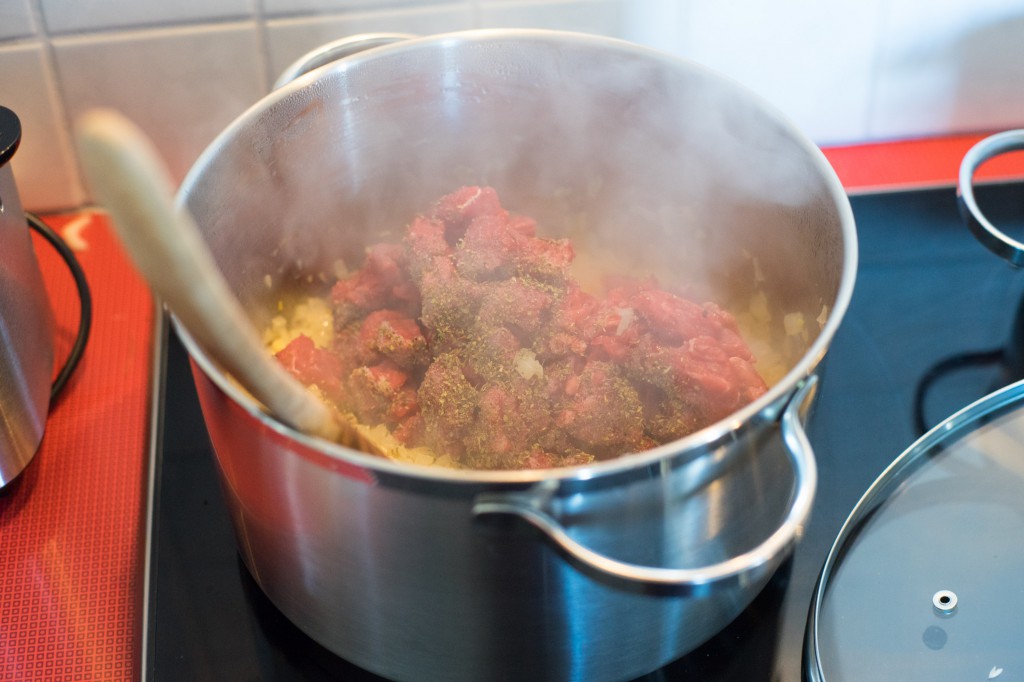 Fleisch zu den gerösteten Zwiebeln geben.