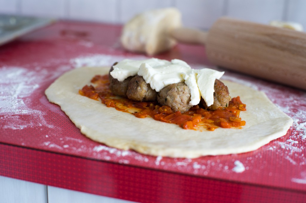 Calzone mit Tomatensauce, Bällchen und Mozzarella füllen.