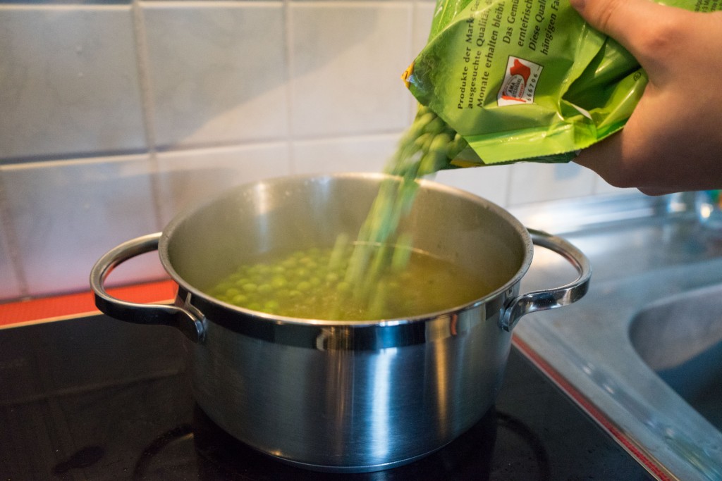 Tiefgefrorene Erbsen in die Suppe geben.