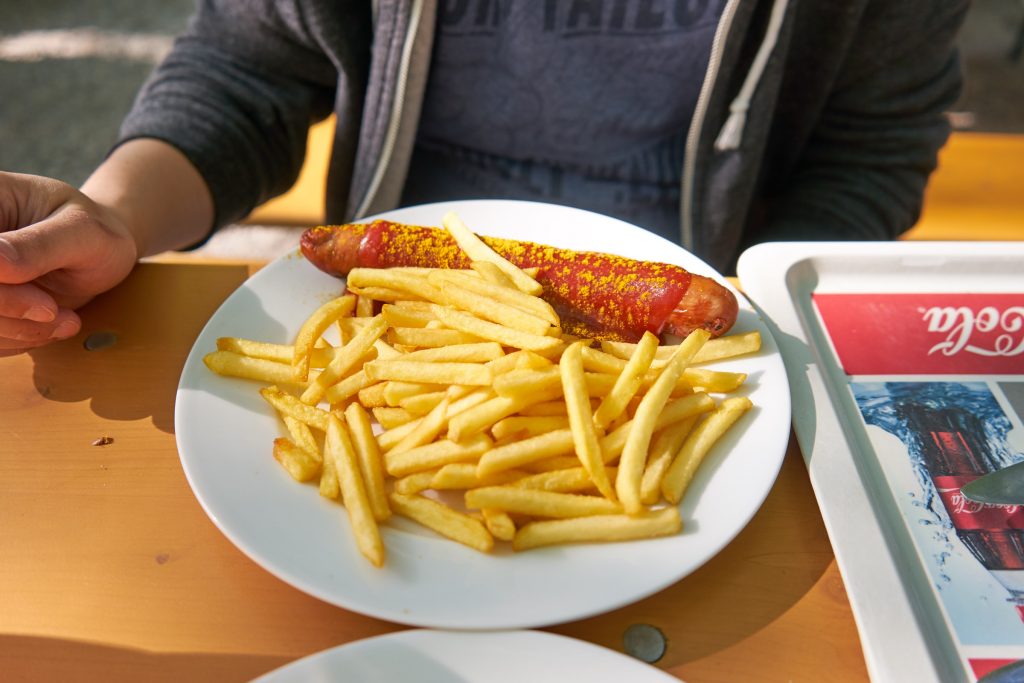 Eine Currywurst mit Pommes.