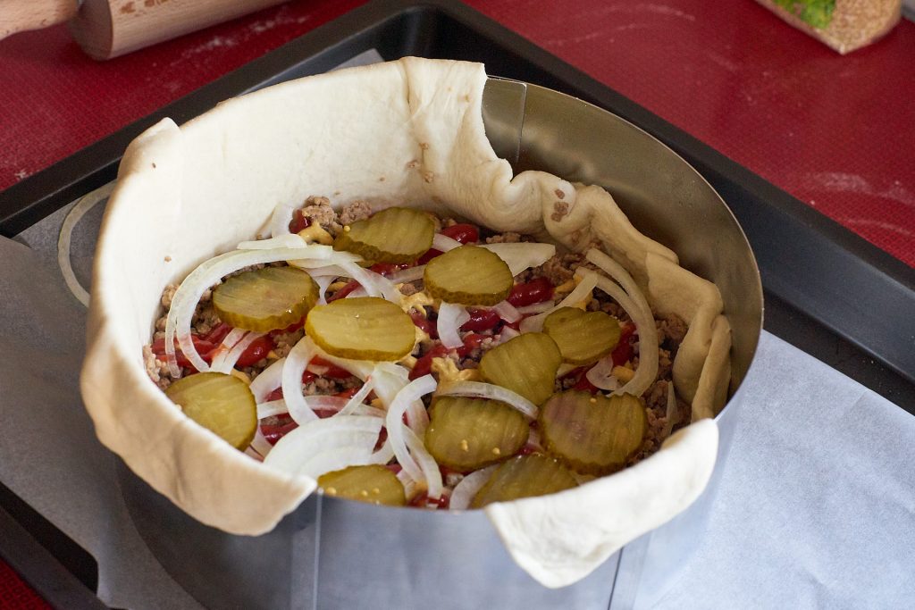 Der Kuchen wird mit Fleisch und anderen Zutaten gefüllt.