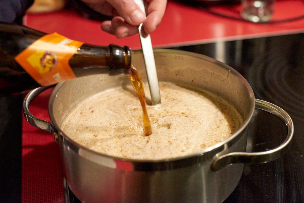 Malzbier wird in den Kochtopf geschüttet.