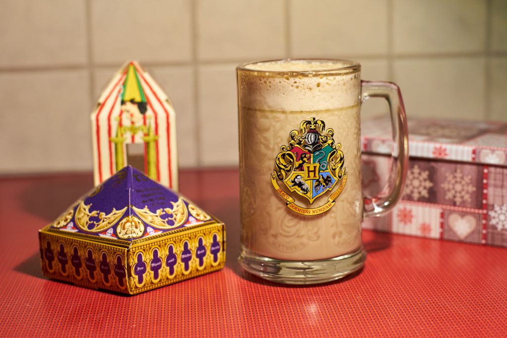 Ein Glas Butterbier und Süßigkeiten aus Hogwarts.