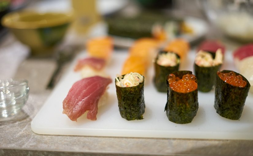 Verschiedene Sushis auf einem Plastikbrett.