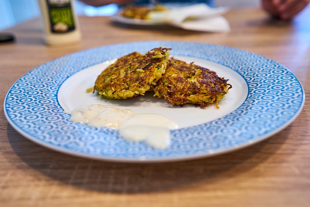 Fertige Gemüse-Rösti mit Sauce angerichtet.