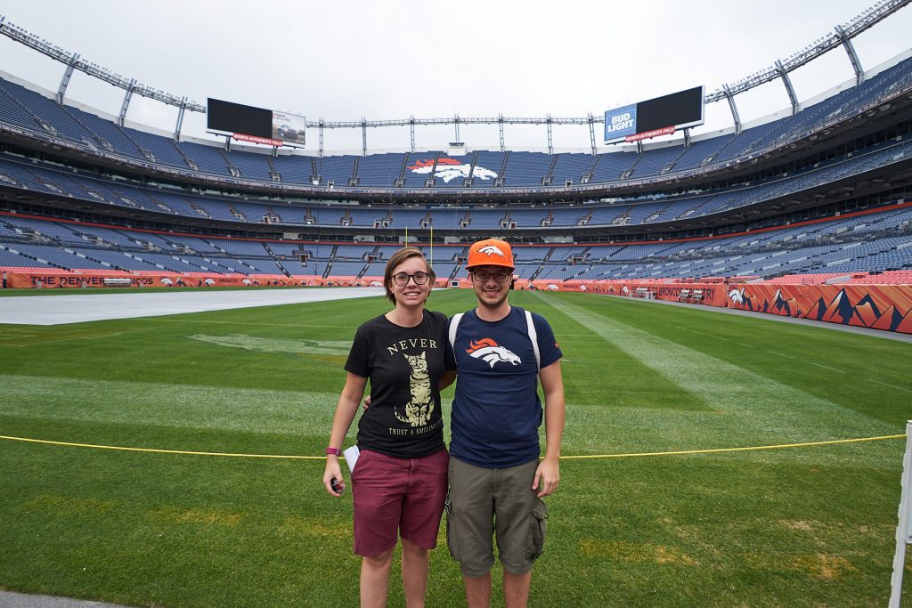 Wir vor dem Football-Feld der Denver Broncos.