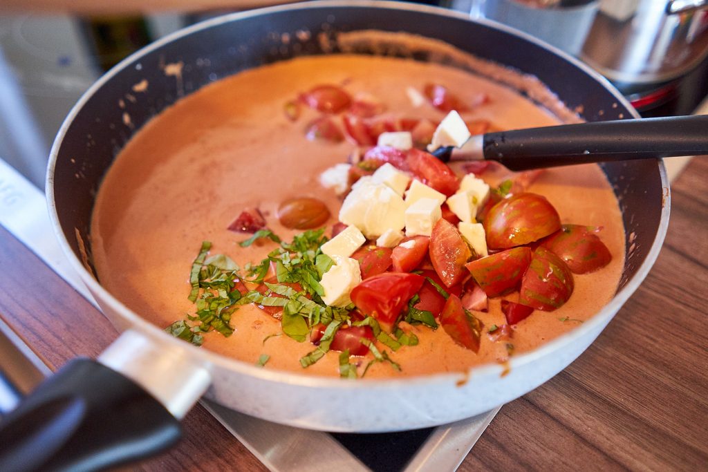 Tomaten, Mozzarella und Basilikum in einer Pfanne.