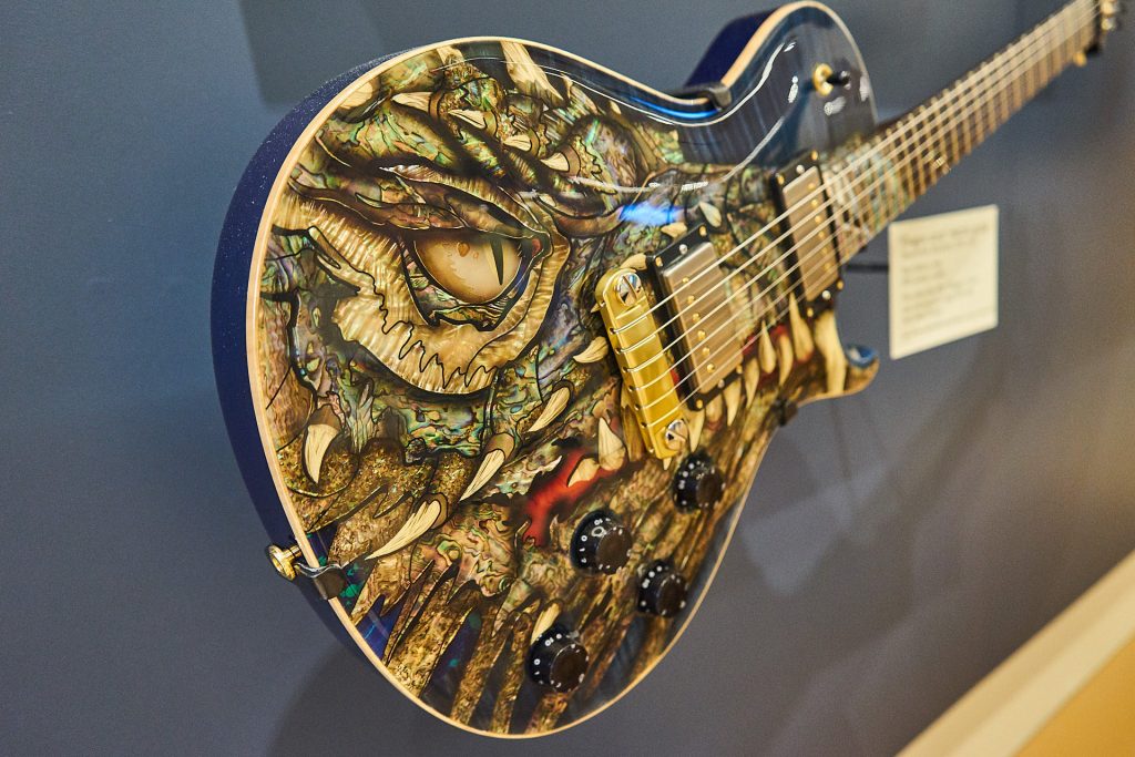 Eine Gitarre mit wunderschönen Perlmutteinlagen - in Form eines Drachen.