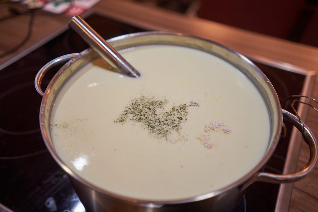 Das Blauschimmelpulver schwimmt auf der Milch.