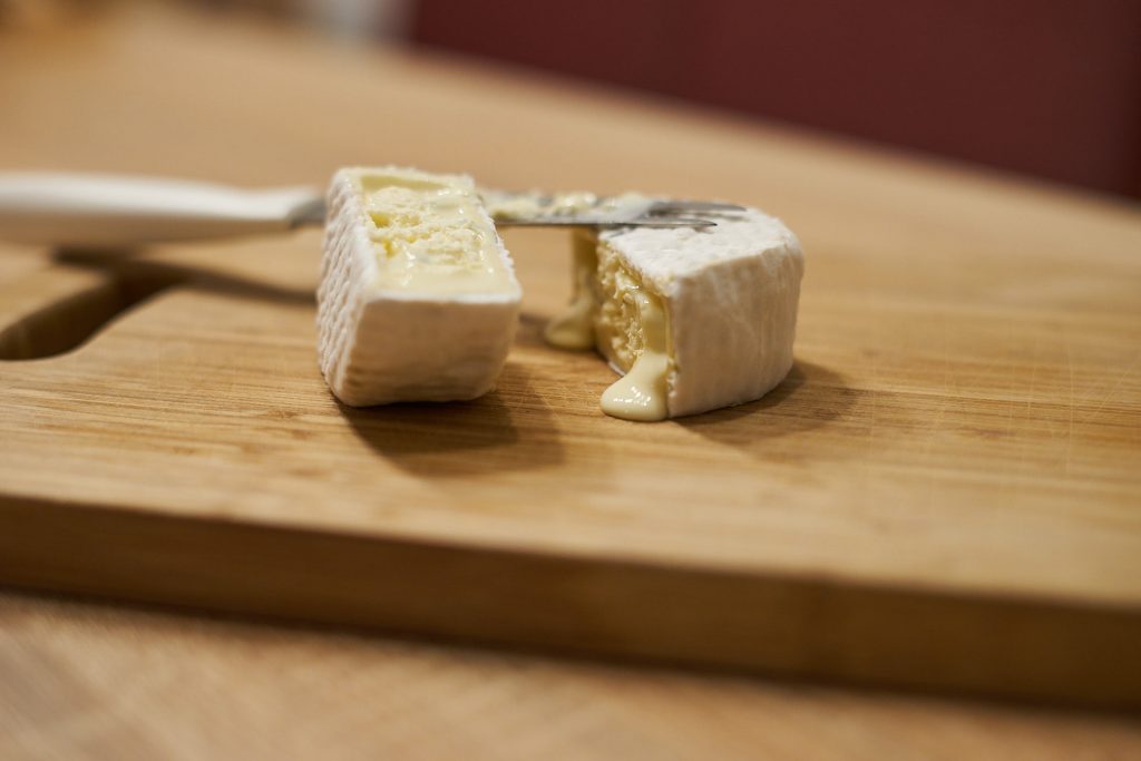 Ein angeschnittener Käse auf dem Jausenbrett.