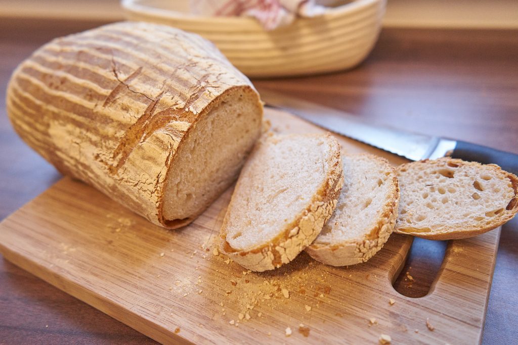 Ein Laib Brot mit ein paar herunter geschnittenen Scheiben.