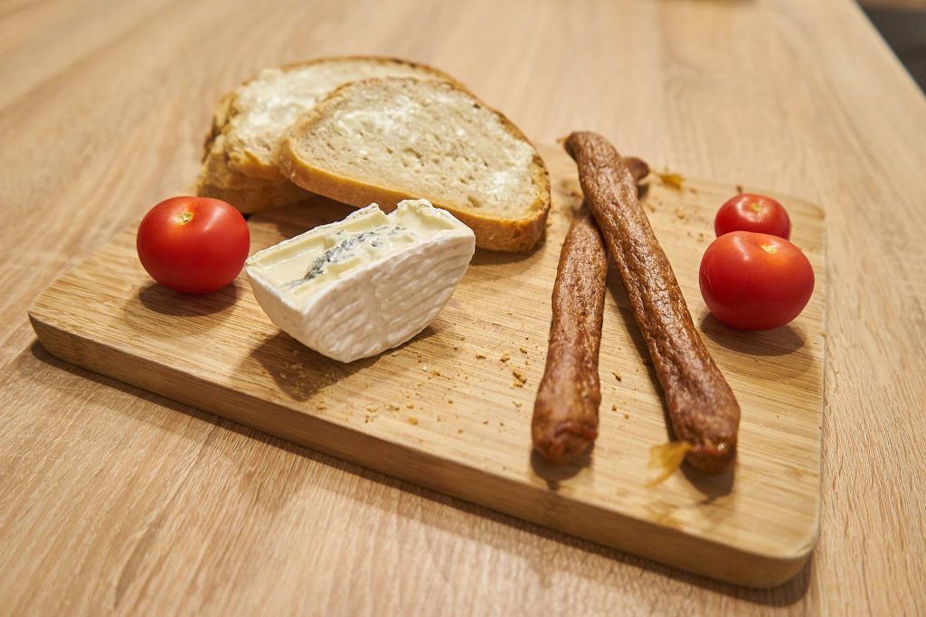 Brot mit Butter, Käse, Würsten und Tomaten.