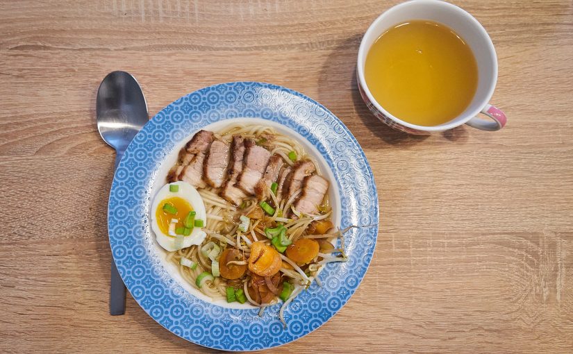 Eine Portion Ramen von oben und eine Tasse Grüntee.